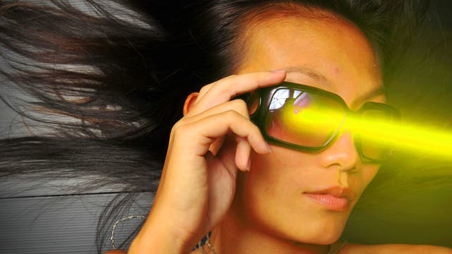Eine junge Frau mit futuristischer Brille und ins Bild montiertem Laserstrahl.