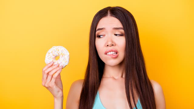 Eine junge Frau führt mit einem Donut ein intensives Zwiegespräch über die Topologie differenzierbarer Mannigfaltigkeiten. Anschließend wird sie ihn essen.