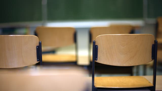 Blick auf eine Reihe von Schulstühlen Richtung Tafel