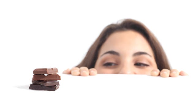 Frau schaut auf Schokolade