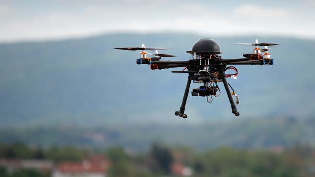 Eine Drohne im Flug vor Landschaft