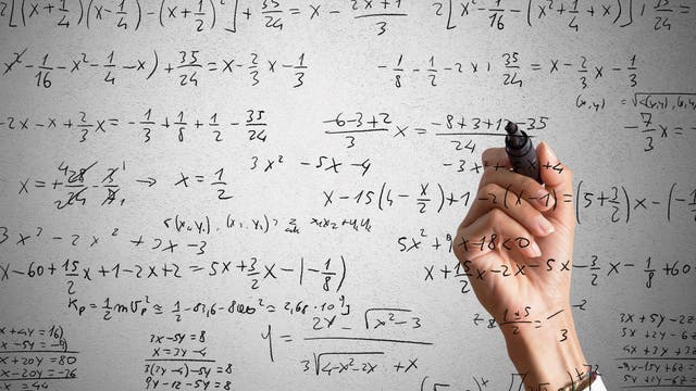 Eine Person schreibt Gleichungen auf eine Glasscheibe. Interessant daran ist, dass sie anscheinend die ganze Zeit in Spiegelschrift schreibt.