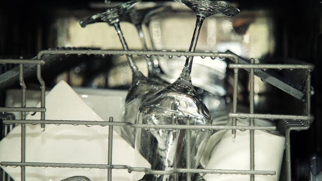 Blick in einen Geschirrspüler mit tropfnassem Geschirr und Gläsern
