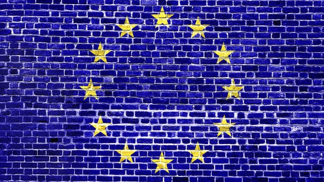 Die EU-Flagge auf einer Backsteinmauer. Oder wie man auf der anderen Seite des Kanals liest: Mene mene tekel u-parsin.