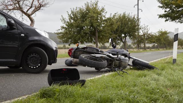 Ein Motorrad liegt vor der Front eines Autos. Das ist natürlich nur ein Symbolbild. Bei einem echten Unfall fliegt das Motorrad viel, viel weiter.