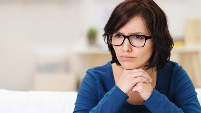 Frau schaut konzentriert und aufmerksam durch ihre Brille