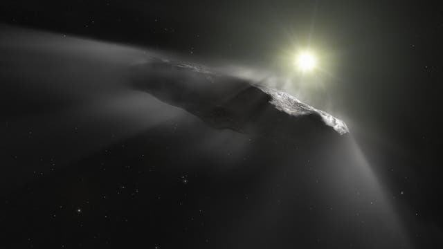 Ein länglicher, dunkler Himmelskörper im Weltraum, der von einem hellen Licht im Hintergrund beleuchtet wird. Der Körper scheint von Sonnenstrahlen umgeben zu sein, die von der Oberfläche reflektiert werden. Im Hintergrund sind zahlreiche kleine Sterne sichtbar. Der Himmelskörper stellt den Komet 3I/ATLAS dar.