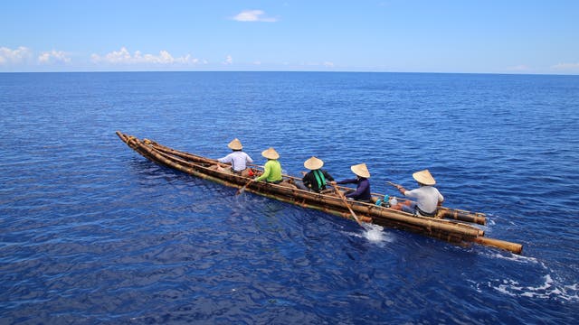 Nachgebautes Bambus-Kanu mit fünf Ruderern
