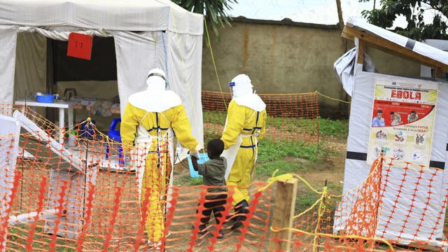 Zwei Ärzte begleiten einen Jungen ins Behandlungszentrum von Beni. Weil die Sicherheitslage Gegenmaßnahmen erschwert, könnte sich die Seuche in der Region etablieren.