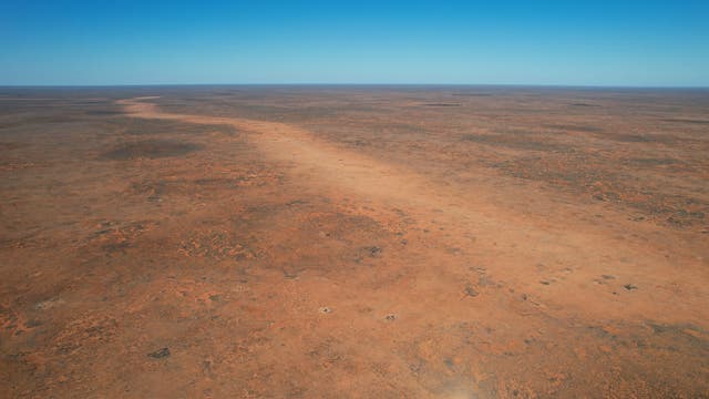 Eine helle Spur in einem baumlosen Wüstengebiet.