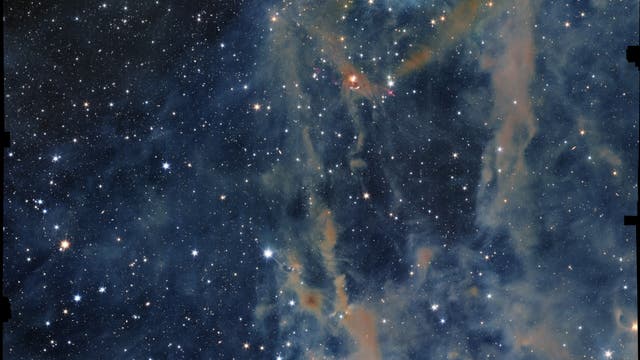 Ein Bild des Weltraums, das einen dichten Sternenhimmel mit zahlreichen leuchtenden Sternen zeigt. Im Vordergrund sind farbige Gas- und Staubwolken zu sehen, die in Blau- und Orangetönen leuchten. Diese Wolken bilden komplexe Strukturen und verleihen dem Bild eine dynamische Tiefe. Der Hintergrund ist dunkel, was die Helligkeit der Sterne und die Details der Nebel betont. Das Bild vermittelt die Weite und Schönheit des Universums.