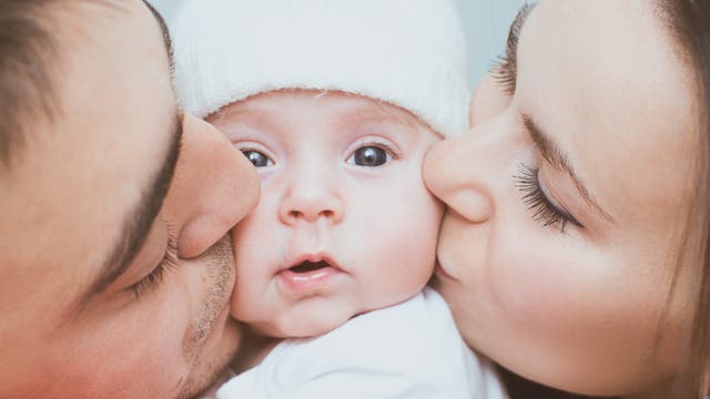 Eltern küssen ihr Baby