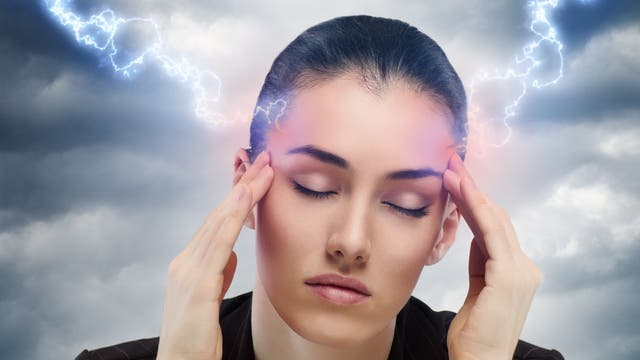 Der Kopf einer leidenden jungen Frau wird mit Blitzen traktiert, um ihr zu helfen