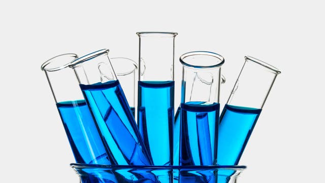 Reagenzgläser mit blauer Lösung in einem großen Becherglas