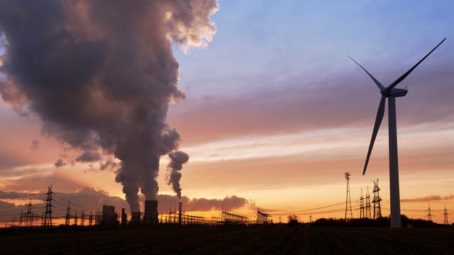 Windenergieanlage und Rauch aus Kohlekraftwerke vor Abendhimmel 