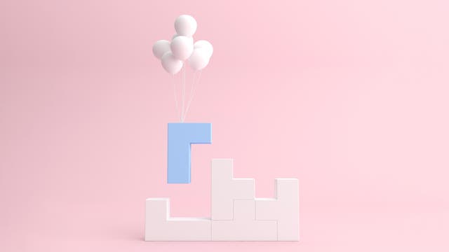 Ein hellblauer, L-förmiger Baustein schwebt über einer Struktur aus weißen, ineinandergreifenden Blöcken. Der blaue Block wird von mehreren weißen Luftballons getragen. Der Hintergrund ist ein sanftes Rosa, das eine ruhige und minimalistische Atmosphäre schafft.