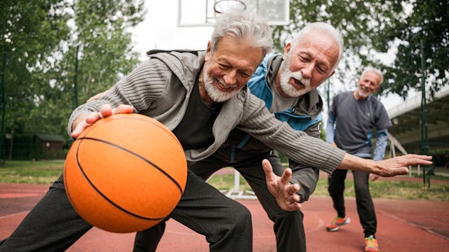 Senioren spielen draußen Basketball