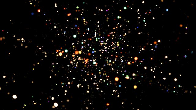 Ein schwarzer Hintergrund mit zahlreichen bunten Lichtpunkten, die wie ein Sternenfeld wirken. Die Punkte variieren in Größe und Farbe, darunter Weiß, Blau, Grün, Rot und Orange, und scheinen in einem dreidimensionalen Raum zu schweben. Die Anordnung der Lichter vermittelt den Eindruck von Tiefe und Bewegung, ähnlich einem Blick in den Nachthimmel oder einem abstrakten Kunstwerk.
