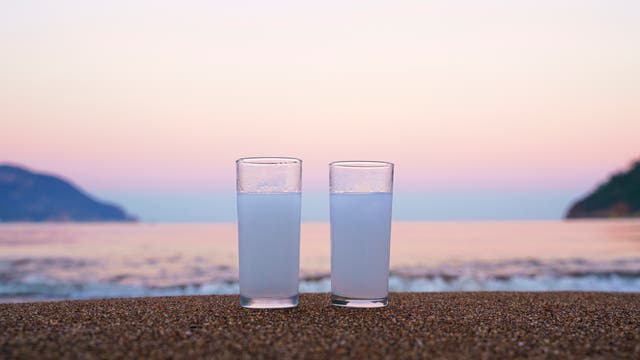 Zwei Gläser mit milchigem Ouzo am Strand