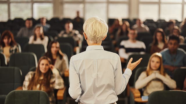 Professorin doziert im Hörsaal vor Studierenden