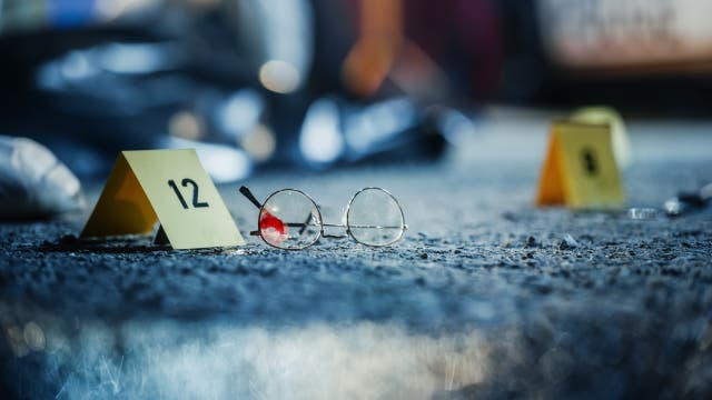 Ein Tatort mit einer blutigen Brille und einem gelben Nummernkärtchen, um die Beweise zu sichern
