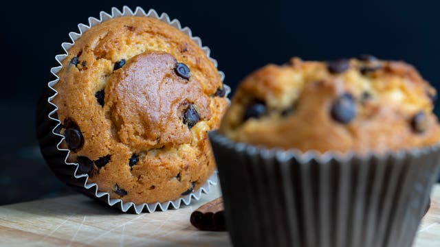 Foto von zwei Muffins mit Schokostückchen, eins liegend, eins stehend