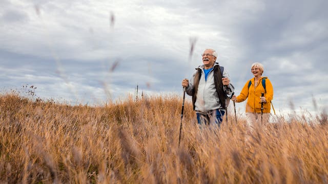 Älteres Paar mit Rucksäcken beim Wandern