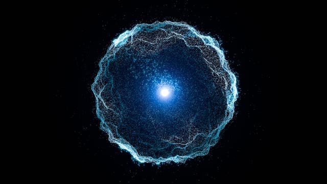Eine leuchtende, blaue Kugel aus zahlreichen kleinen Partikeln schwebt in der Mitte eines schwarzen Hintergrunds. Die Partikel formen eine wellenartige, kreisförmige Struktur um einen zentralen, hellen Lichtpunkt. Die Anordnung erinnert an eine abstrakte Darstellung eines Energiefeldes oder einer Galaxie. Die Partikel scheinen sich dynamisch zu bewegen und erzeugen einen Eindruck von Tiefe und Bewegung.