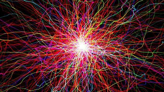 Ein komplexes Netz aus leuchtenden, bunten Linien, die von einem zentralen, hellen Punkt in alle Richtungen strahlen. Die Linien sind in verschiedenen Farben wie Rot, Blau, Gelb und Grün gehalten und erzeugen ein dynamisches, chaotisches Muster auf schwarzem Hintergrund. Das Bild erinnert an ein Feuerwerk oder neuronale Verbindungen und vermittelt ein Gefühl von Energie und Bewegung.