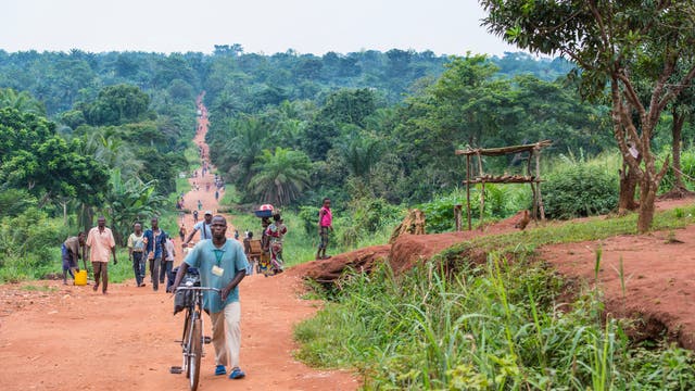 Blick auf eine unbefestigte Straße mit Personen in der Demokratischen Republik Kongo.