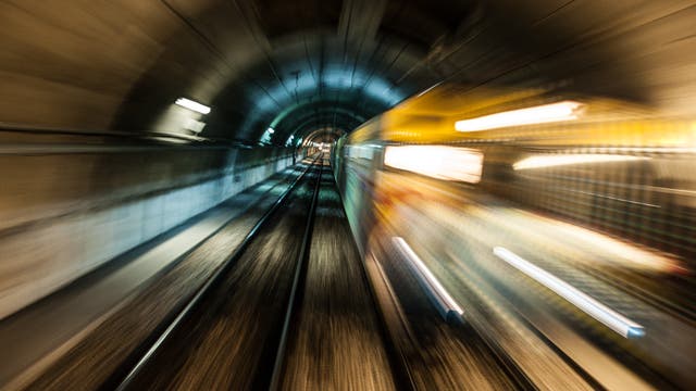 Mit Bewegungsunschärfe fährt eine U-Bahn durch einen Tunnel