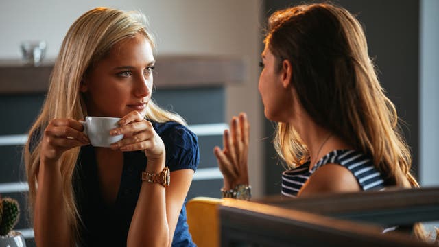 Zwei Frauen tauschen Neuigkeiten aus beim Kaffeetrinken