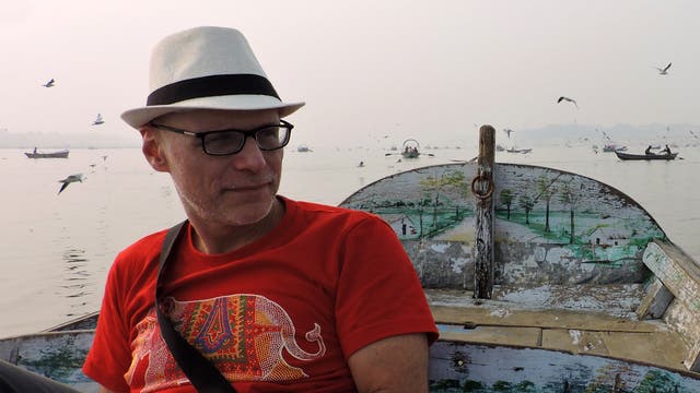 Der Psychologe Arne Dietrich sitzt auf einem Boot. Im Hintergrund sind weitere Boote und Vögel zu sehen.