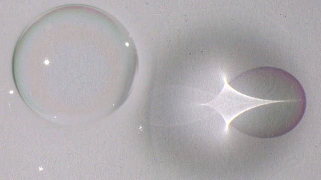 Eine einzelne Blase hinterlässt nicht nur einen schemenhaften Schatten auf dem Boden eines Behälters, sondern auch ein Lichtkreuz und unterschiedliche Farbphänomene. 