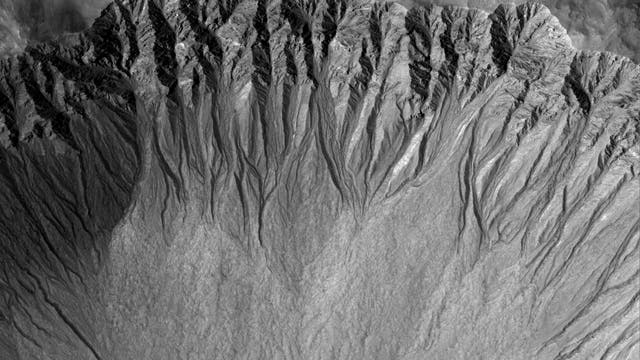 So genannte Gullies, Erosionsrinnen in marsianischen Kraterwänden