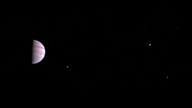 Junos erstes Bild aus dem Jupiterorbit mit Jupiter in Halbphase und drei Monden