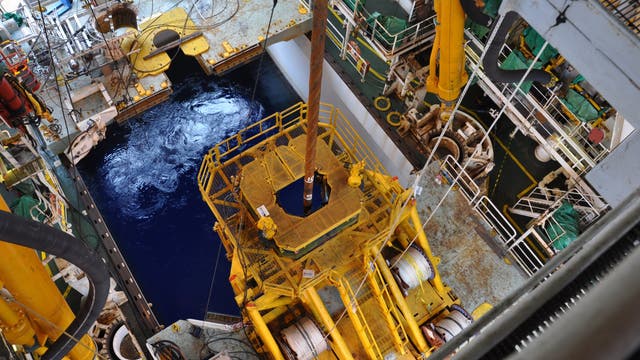 Blick in den Bohrschacht des Bohrschiffes Chikyu mit Bohrer, der zur Wasseroberfläche hinabgelassen wird.