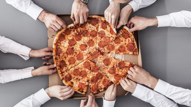 Arbeitskollegen essen gemeinsam Pizza 