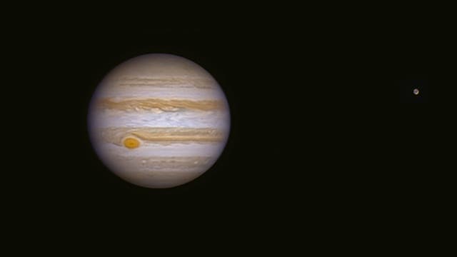 Jupiter und sein Mond Ganymed in der Schwärze des Weltalls.