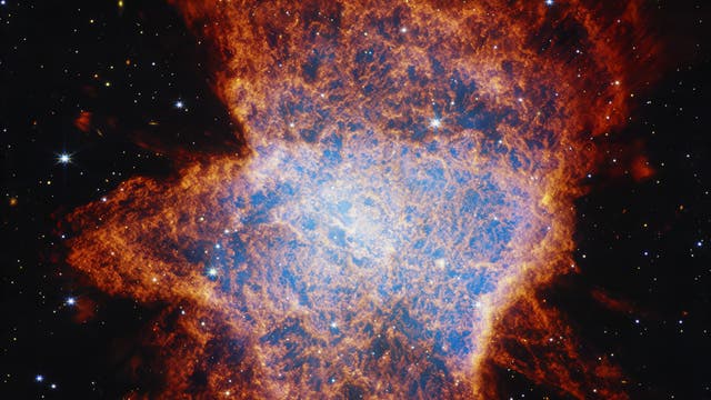 Ein leuchtendes astronomisches Bild zeigt einen Planetarischen Nebel im Weltraum. Im Zentrum befindet sich eine helle, blaue Region, umgeben von einer ausgedehnten, rötlichen Gaswolke. Der Hintergrund ist mit zahlreichen kleinen, funkelnden Sternen übersät. Dieses Bild veranschaulicht die komplexe Struktur und die Farbenvielfalt eines sterbenden Sterns, der seine äußeren Schichten abstößt.