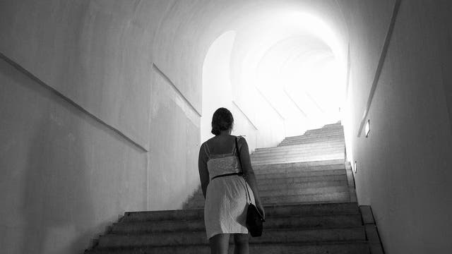 Frau steigt Treppe in Tunnel hinauf. Symbolbild: zum Licht!