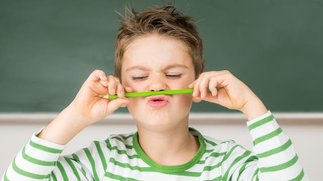 Schuljunge spielt mit Stift 