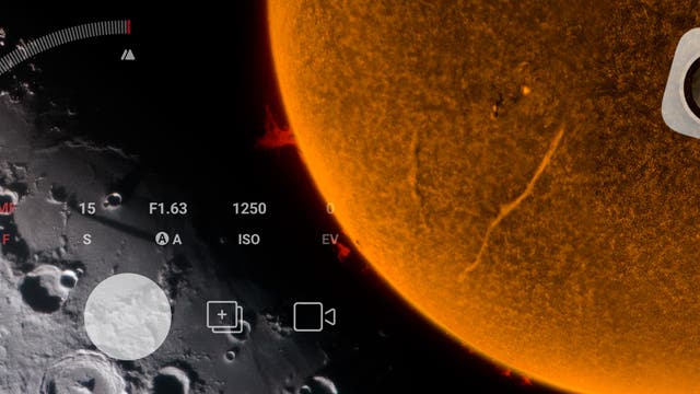 Das Bild zeigt eine künstlerische Darstellung des Mondes und der Sonne. Links ist die graue, kraterbedeckte Oberfläche des Mondes zu sehen, während rechts die orangefarbene, strukturierte Oberfläche der Sonne mit sichtbaren Protuberanzen dargestellt ist. Überlagert sind Kameraeinstellungen wie ISO, Blende und Weißabgleich, die den Eindruck einer fotografischen Aufnahme vermitteln.