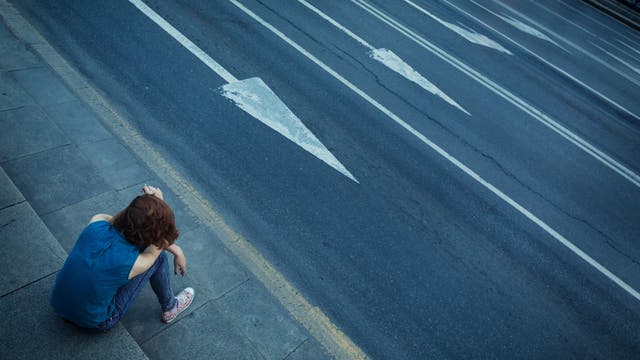 Ein Teenager an einer vierspurigen Straße