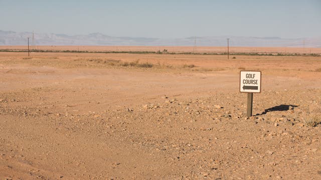 Schild weist auf einen Golfplatz in der Wüste hin