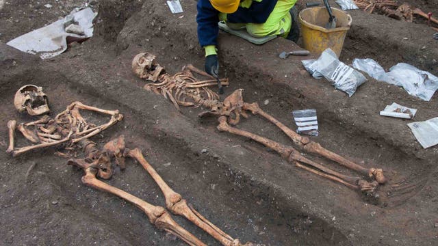 Eine Archäologe legt die Skelette von mittelalterlichen Mönchen auf einem Friedhof in Cambridge frei.