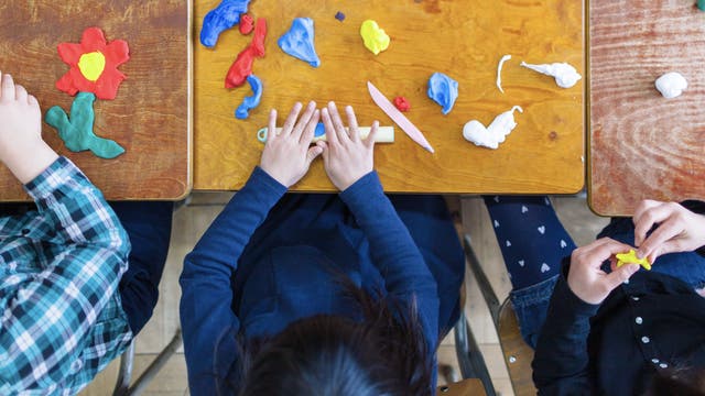 Kinder spielen im Kindergarten mit Knete.