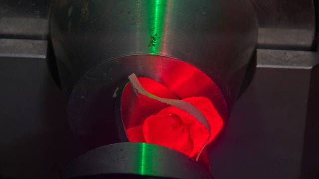 Rotes Gummibärchen im physikalischen Text - fixiert und bereit für den Positronenbeschuss