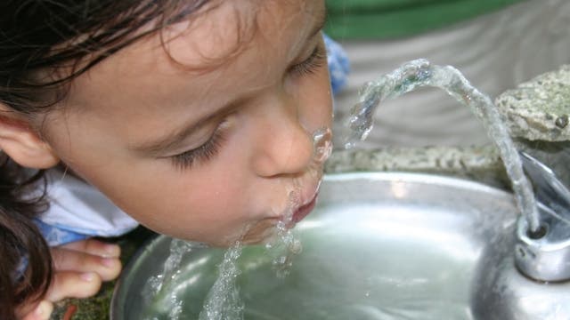 Mädchen trinkt aus einem anscheinend öffentlichen Trinkwasserbrunnen. Ob Eltern heutzutage so was noch erlauben würden?