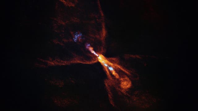 Ein leuchtendes, farbenfrohes Bild eines kosmischen Phänomens im Weltraum. Es zeigt eine zentrale, helle Struktur mit orangefarbenen und blauen Strahlen, die sich in verschiedene Richtungen ausbreiten. Die Umgebung ist dunkel, was die leuchtenden Farben hervorhebt. Dieses Bild könnte ein astronomisches Ereignis wie einen Nebel oder eine Galaxie darstellen. Es gibt keinen Text im Bild und keine verlinkte URL.